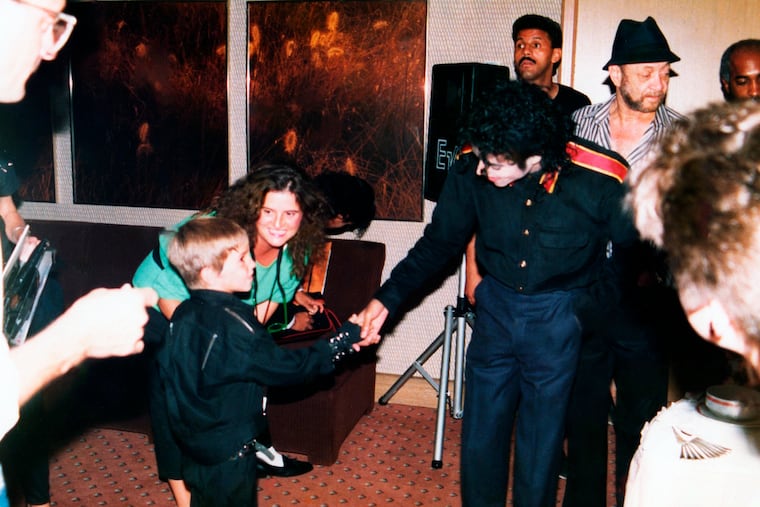 This image released by HBO shows a young Wade Robson shaking hands with pop icon Michael Jackson in 1987, in a scene from the documentary "Leaving Neverland." The unsparing documentary about Jackson and his alleged sexual abuse is already the third most-watched documentary of the past decade at the prime cable network, which takes pride in its documentary schedule. The Nielsen company said the first half of the four-hour program has been seen by 3.67 million people.