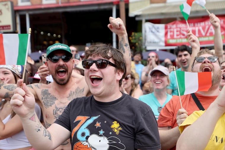 Dylan Leahy (center), of Washington Square West, cheers for a friend competing in the Grease Pole Climbing Competition during the South 9th Street Italian Market Festival in Philadelphia on Sunday, May 18, 2025.