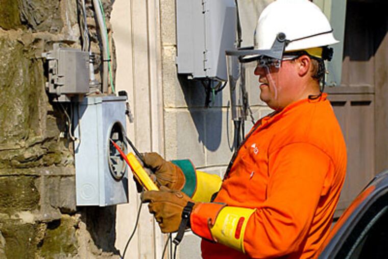 PECO worker Ralph Colon checks to make sure proper power is moving through contacts as he inspects meters in alleyway in Upper Darby. ( Tom Gralish / Staff Photographer )