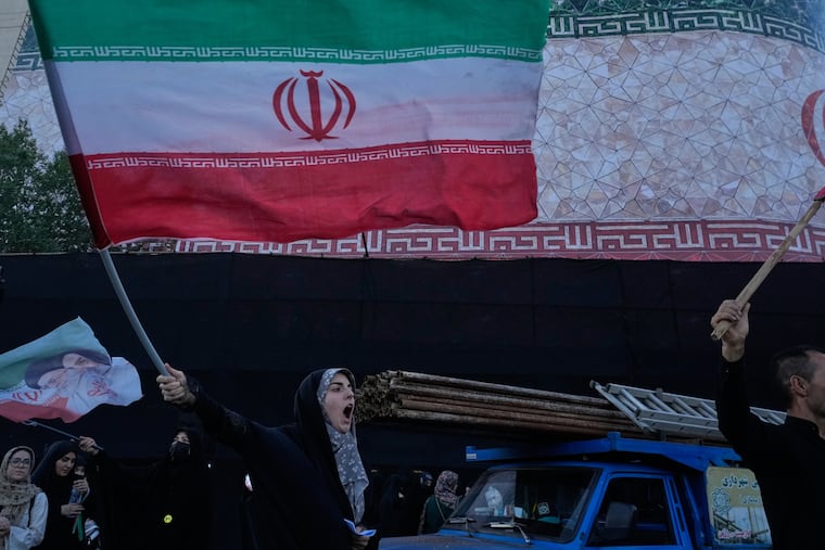A woman waves an Iranian flags as she chants slogans against Iran and U.S. talks at the Islamic Revolution square in Tehran, Iran, Sunday, June 14, 2026.