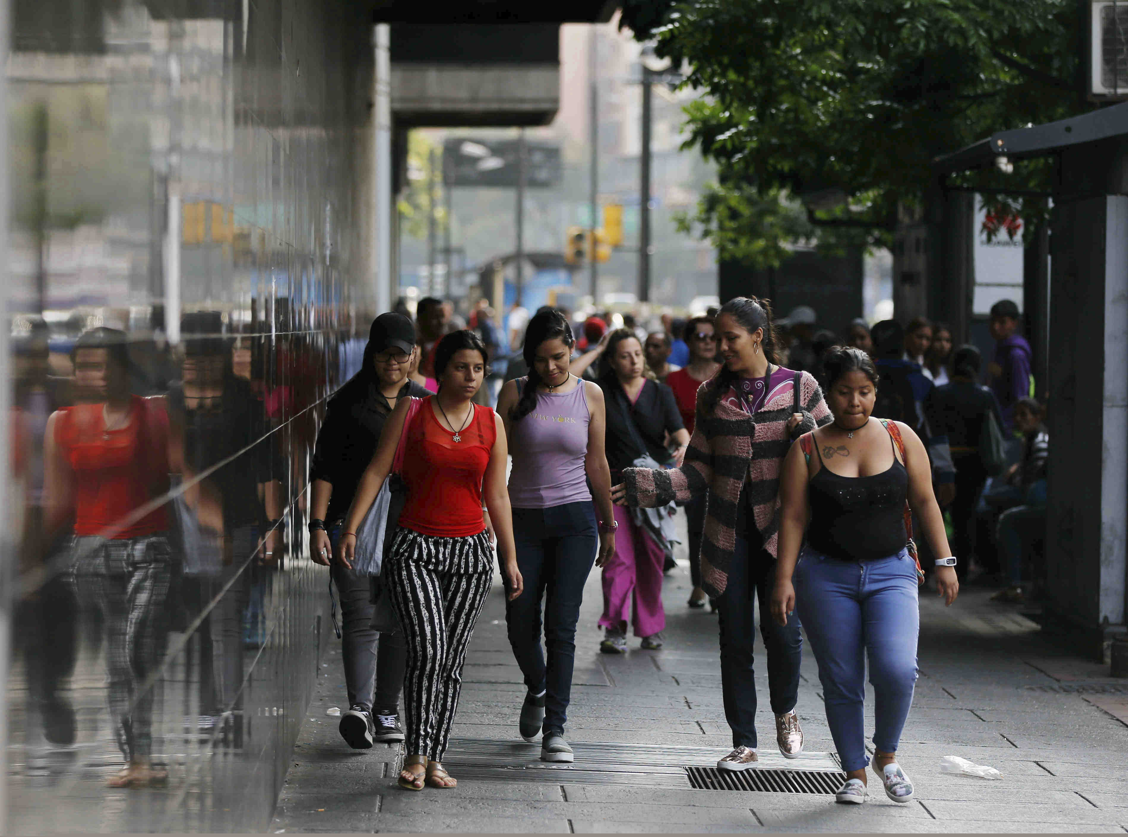 Pedestrians walk to their destination amid the country’s worst-ever power outage, in Caracas, Venezuela, Friday, March 8, 2019. President Nicolas Maduro ordered schools and all government entities closed and told businesses not to open to facilitate work crews trying to restore power.