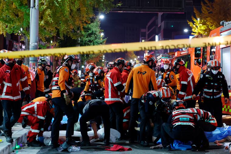 Rescue workers and firefighters work on the scene of a crushing accident in Seoul, South Korea, Saturday, Oct. 29, 2022.