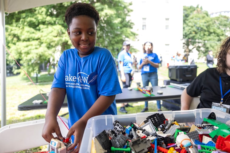 Sam Okyere, 12, plays against Corey Samuels, 41, of Princeton, N.J., a "LEGO Masters" winner, during his Make-A-Wish donation drive and block party at Families Forward Philadelphia homeless shelter.