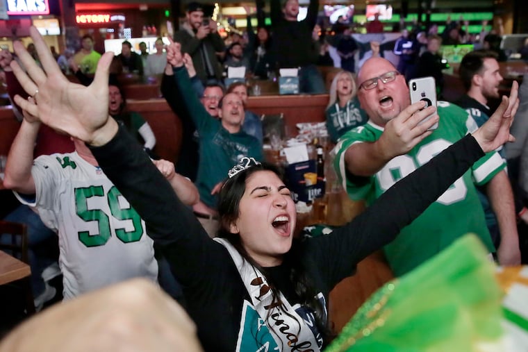 Arianna Grott of Delaware (center) and other Eagles fans at Xfinity Live! Philadelphia cheer as the game winds down and the Eagles defeat the LA Rams 30-23 on December 16, 2018.