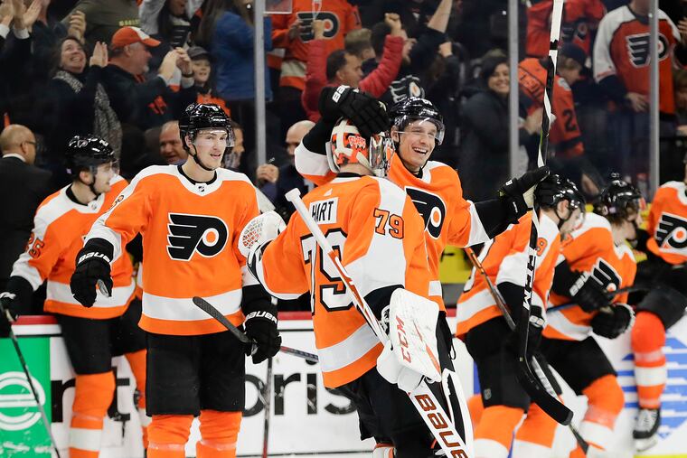 Flyers goaltender Carter Hart and defenseman Justin Braun celebrate after the team's 3-2 overtime win over the Canadiens on Thursday night.