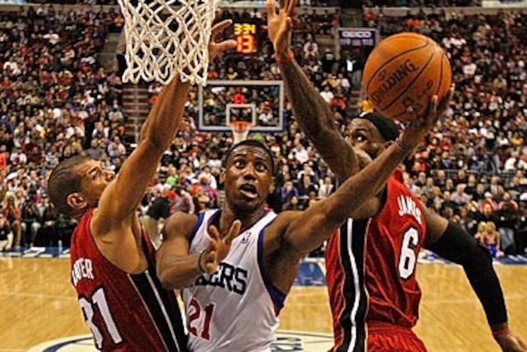 Sixers forward Thad Young goes up for a shot between LeBron James and Shane Battier. (Ron Cortes/Staff Photographer)