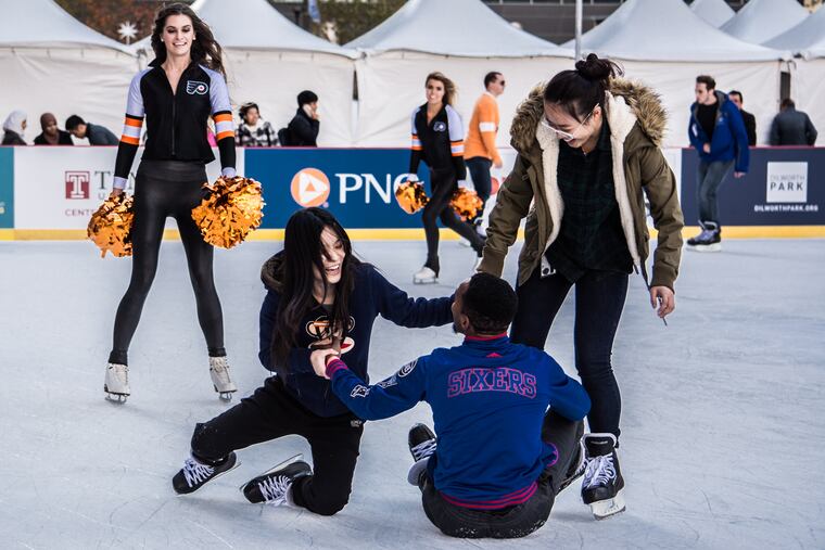 Dandi Li falls down laughing while skating the newly reopened Rothman Institute Ice Rink in Dilworth Park on Friday, Nov. 13, 2015.