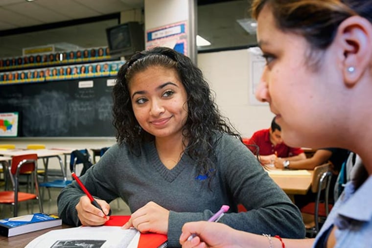 With more than 1,000 students from 70 countries, Upper Darby's English Language Program is one of the biggest and most diverse in the Phila. region. Here, peer tutor Amrit Kaur smiles as she listens to her pupil Anel Gaspariano on Tuesday December 3, 2013. ( ED HILLE / Staff Photographer )