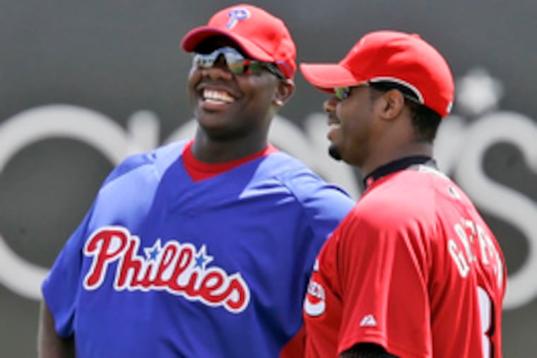 Ryan Howard talks with another slugger of note, Cincinnati's Ken Griffey Jr. (right), before yesterday's Phillies-Reds game. Who will hit behind Howard, who smacked 58 homers last year, in the Phils' lineup has been a topic of debate for months.