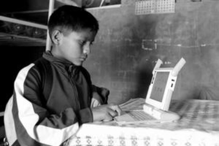 Kevin, 11, surfs the Internet at his Andean hilltop village in Peru. The laptops prompted families to move to the rural locale.