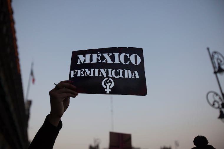 A demonstrator holds up a stencil of the Spanish message: "Mexico Femicide" in Mexico City on Friday. The demonstration against gender violence comes after last week's vicious murder of Ingrid Escamilla by her husband and controversy unleashed by the leaking of images of her body to the press, in a country where an average of 10 women are killed every day.