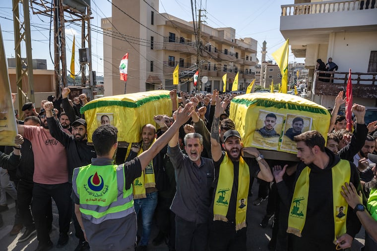 FILE — Mourners carry coffins during a funeral for two members of Hezbollah in the southern Lebanese village of Toura, April 22, 2026. U.S. and Iranian officials say they are closing in on the terms of a preliminary agreement; yet sticking points, particularly over the Strait of Hormuz, remain.