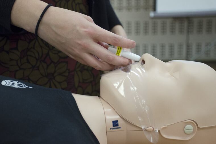 Harm Reduction Coordinator Allison Herens administers a Narcan nasal spray to a test dummy during an opioid public awareness campaign at the Philadelphia Department of Public Health in Center City on Thursday, March 15, 2018. This nasal spray needs no assembly and can be sprayed in one nostril by pushing a plunger. ( CAMERON HART / For the Inquirer )