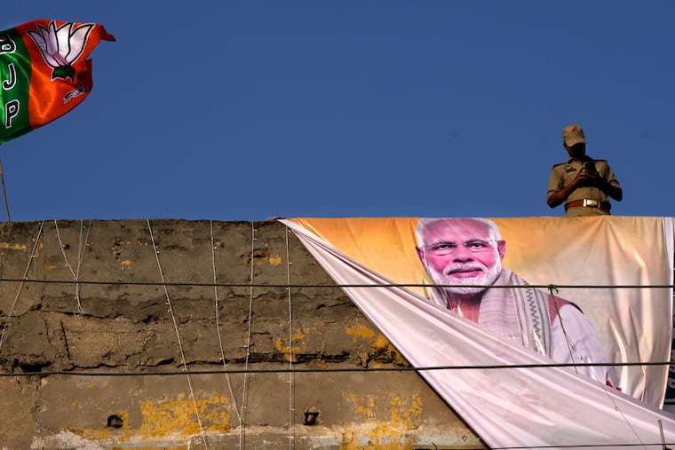 A policeman keeps watch from the roof of a building during a campaign rally by Indian Prime Minister Narendra Modi for his Bharatiya Janata Party (BJP) ahead of parliamentary elections in Ghaziabad, India, April 6, 2024. Modi is campaigning for a third term in the general election starting Friday.