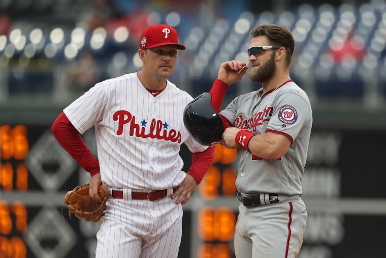 Rhys Hoskins (left) and Bryce Harper chat during a replay during a game on Sept. 11 vs. the Nationals on Sept. 11.