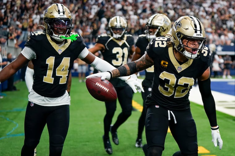 New Orleans Saints safety Tyrann Mathieu (right) reacts with teammates, including Kool-Aid McKinstry (left) after intercepting a pass against Dallas.