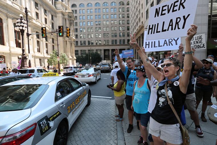 Dixie Stephens of Murfreesboro, Tenn., ( right) holds up her sign and shouts support for Bernie Sanders as traffic moves by on the south side of City Hall on Monday July 25, 2016, the first day of the DNC.