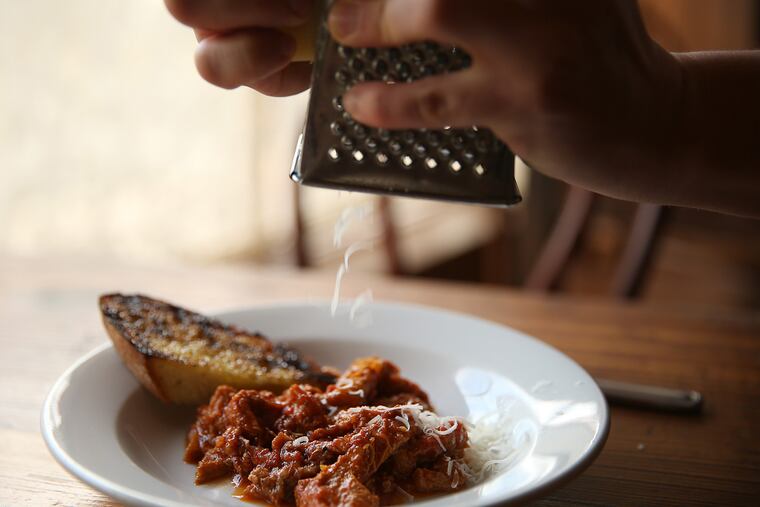 Chef Joey Baldino grates cheese over the tripe dish at Zeppoli in Collingswood.