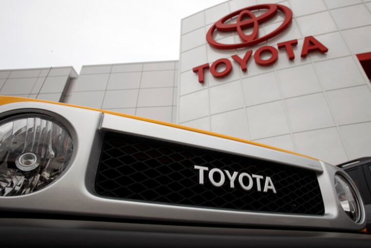 Unsold Ford trucks, at left, reflect in the grille of a 2009 Super Duty. Toyota logo on a 2009 FJ Cruiser. Car sales in Nov. were abysmal.