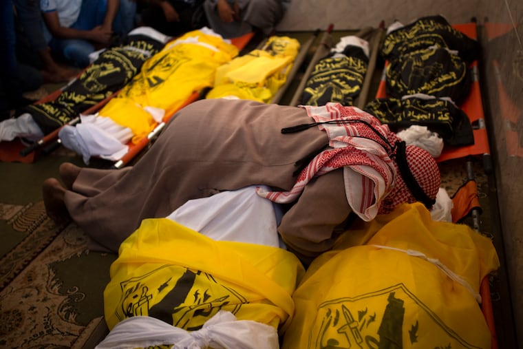 Palestinians mourn over the bodies of Rasmi Abu Malhous and seven of his family members who were killed in overnight Israeli missile strikes that targeted their house, in a mosque during their funeral in town of Deir al-Balah, central Gaza Strip on Thursday.