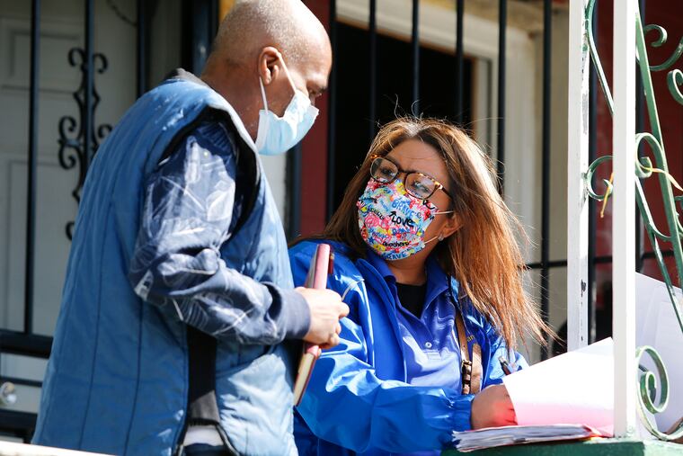 Quetcy Lozada (right) helps register resident Jeff Harris for a COVID-19 vaccination in the Hunting Park neighborhood of North Philadelphia. Lozada is the Democratic nominee in the special election for City Council's 7th District.