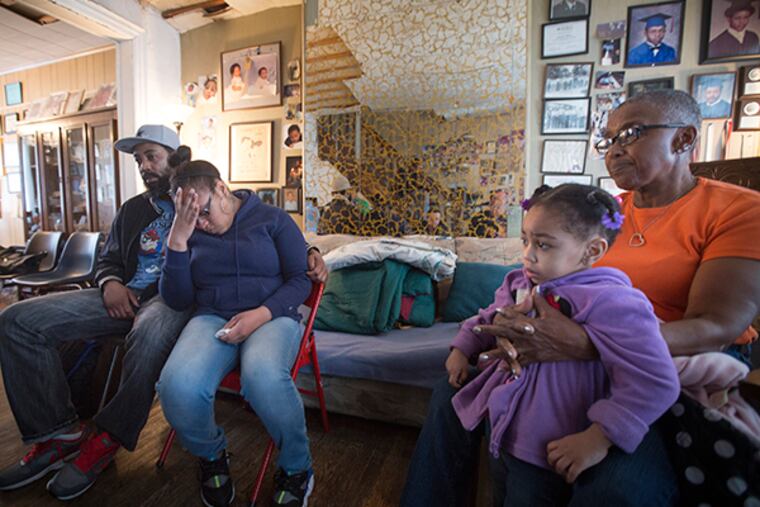 Troy Burroughs, brother-in-law, Shakira Wilson-Burroughs, sister, and Constance Wilson, grandmother, holding niece, Sytira, of fallen police officer Robert Wilson, as they speak about him Saturday, March 7, 2015. ( DAVID SWANSON / Staff Photographer )