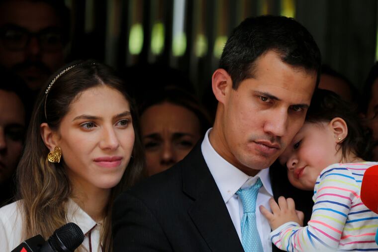 Opposition National Assembly President Juan Guaido, accompanied by his wife Fabiana Rosales and his 20-month-old daughter Miranda, listens to a reporter's question during a news conference outside their apartment, in Caracas, Venezuela, Thursday, Jan. 31, 2019. Guaido said security forces showed up at their home in an attempt to intimidate him. "The dictatorship thinks it can intimidate us," Guaido said.