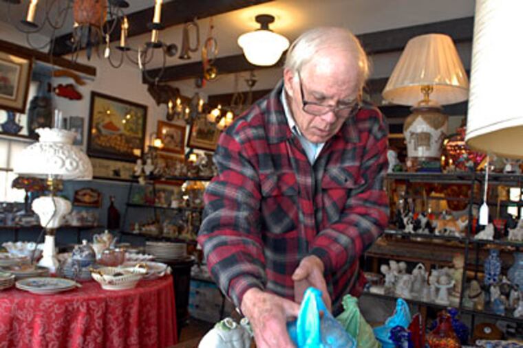 Stuart Ballard adjusts inventory at the Old Warrington School House Gift Shop. "It's a shade better," he said of business this year. (Ron Tarver / Staff Photographer)