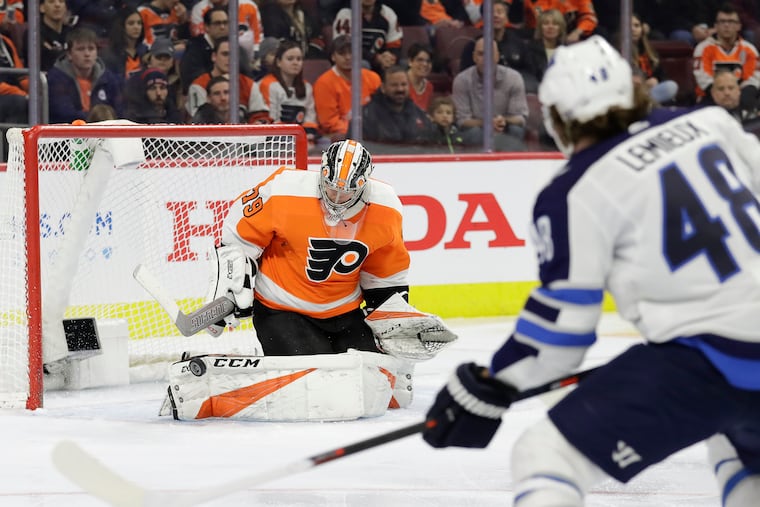 Flyers goaltender Carter Hart stops a second-period shot by Winnipeg left winger Brendan Lemieux on Monday.