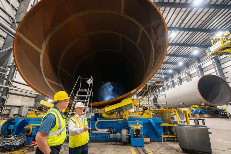 Former state Senate president Steve Sweeney (left) takes a tour at the Paulsboro factory where Germany-based multinational pipemaker EEW had begun building massive cylindrical supports for New Jersey's planned ocean wind electric plants before the program was canceled.