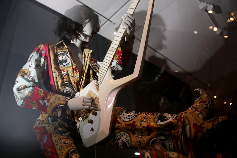 An outfit and guitar used by Prince are displayed at the exhibit "Play It Loud: Instruments of Rock & Roll," at the Metropolitan Museum of Art in New York, Monday, April 1, 2019. The exhibit, which showcases the instruments of rock and roll legends, opens to the public on April 8 and runs until Oct. 1, 2019.