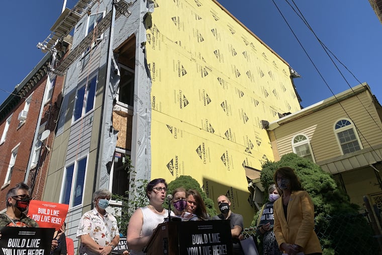 Michelle Gaffney reads a statement by Nancy Lewis, to her left in the purple mask, whose property has been damaged by construction on the other side of her twin home in Kensington.