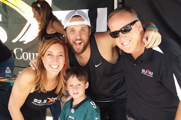 Andie Summers, Kevin Crockett and Ken Doc Medek -- WXTU's morning crew -- with a young Eagles fan at an August event.
