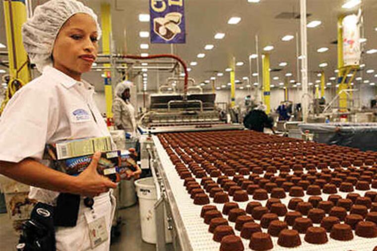 Tastykake taste-tester Shelly McDonnough watches a line of cupcakes fresh from the oven. "I pretty much eat the whole thing," she says of her tasting. (Juliette Lynch / Staff Photographer)