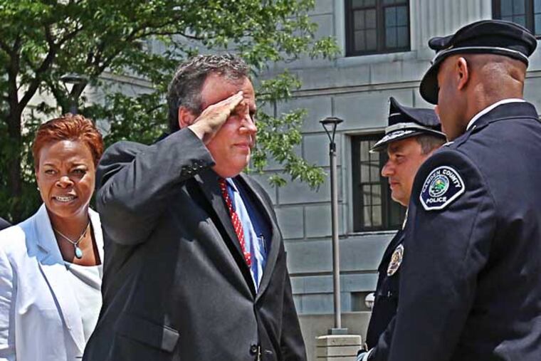 New Jersey Governor Chris Christie, left, salutes the Comand Staff of the Camden County Police Department in front of Camden City Hall on Tuesday june 3, 2014. Camden Mayor Dana Redd, extreme left, was there to welcome the governor. Gov. Christie comes to Camden to discuss crime statistics and welcome a new class of rookies to the county force ( Michael Bryant / Staff Photographer )