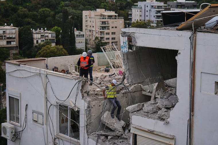 Israeli authorities inspect a damaged house following an Iranian missile strike in Haifa, Israel, Monday, March 30, 2026.