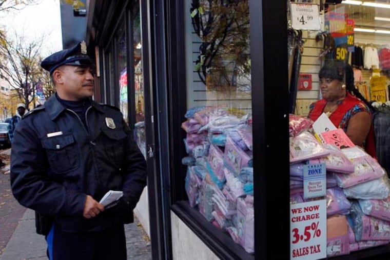 In this Nov. 17, 2010 photo, Camden Police Officer L.A. Sanchez walks a beat in a downtown shopping area in Camden, N.J. Mayor Dana Redd said last week that the proposed layoffs would not be as deep as the worst-case scenario she laid out last month that called for laying off 225 of the 375-member police force, including dispatchers and civilian staff. Police Chief Scott Thomson says that when layoffs come, he will realign his force in ways that the public won't notice. "The Camden Police Department will not abandon its community policing philosophy," said Thomson. (AP Photo/Mel Evans)