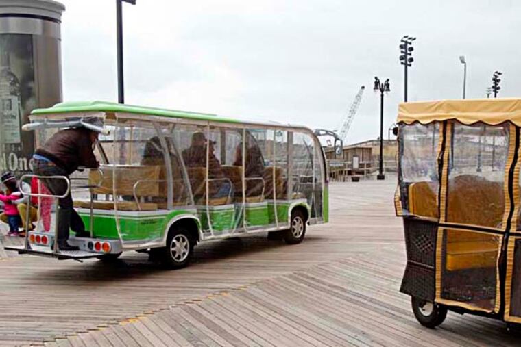 A Boardwalk Jitney is passing a traditional rolling cart. ( AKIRA SUWA / Staff Photographer )