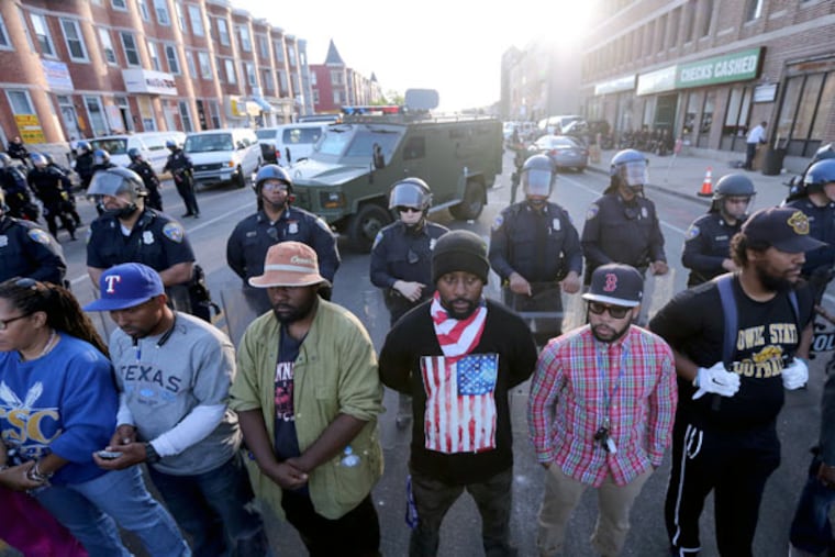 Baltimore police and protesters in a calm moment Tuesday at West North and Pennsylvania avenues. (DAVID SWANSON / STAFF PHOTOGRAPHER)