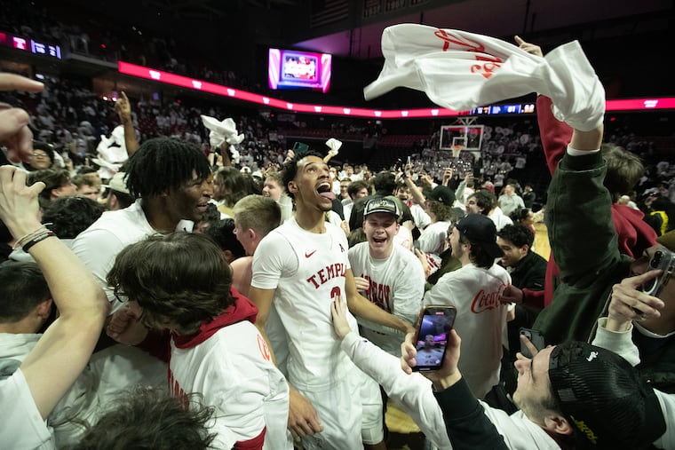 Temple's Steve Settle III celebrates with students who stormed the court after the Owls upset AAC foe Memphis.
