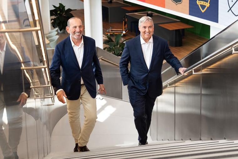 Larry Berg (right) with the man he'll succeed as MLS commissioner, Don Garber, at the league's headquarters on Monday.