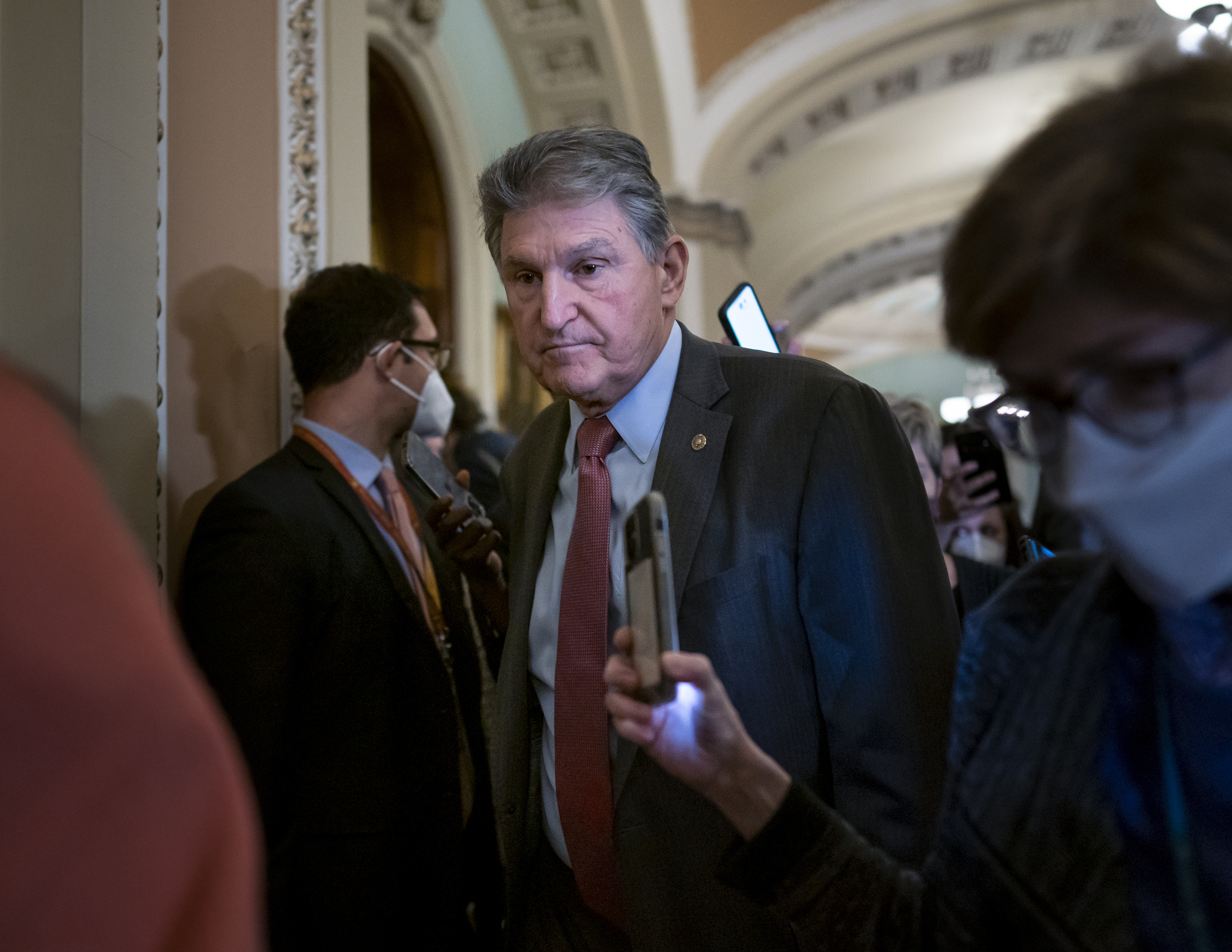 Sen. Joe Manchin, shown making his way through a crowd of reporters at the Capitol in Washington on Tuesday.