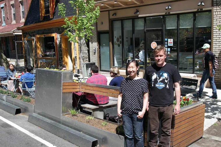 Jeanne Chang, left, owner of Lil' Pop Shop, and Tom McCusker, right, owner of Honest Tom's, pose in front of the parklet outside their shops in West Philadelphia on May 6, 2014. ( DAVID MAIALETTI / Staff Photographer )