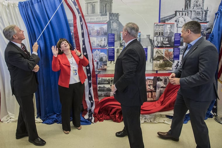 Chellie Cameron, Airport CEO, second from left, reacts as the bunting that was hiding the new art exhibit at the airport was pulled down by John Smith, left, Board Chair of Global Philadelphia Association, Mayor Jim Kenney, and Jeff Guaracini, Director of Wawa Welcome America, on Wednesday, June 28, 2017.
