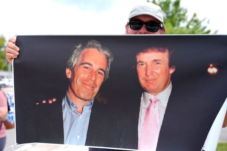 A protester holds up a photo of the future President Donald Trump with financier Jeffrey Epstein at a rally in Augusta, Georgia, in August.