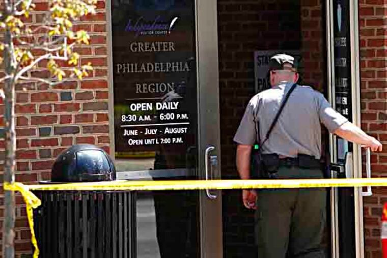 A park ranger enters the building after police evacuate the Independence Visitor Center in Philadelphia April 21, 2013. Lt. Joseph McGarrey said the center was evacuated after a "suspicious person" dressed in camouflage fatigues and driving a vehicle loaded with many "items" - including paper and clothing - was detained for questioning. ( DAVID MAIALETTI / Staff Photographer )
