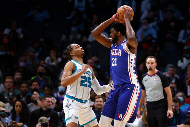 Joel Embiid (21) of the Philadelphia 76ers is closely guarded by P.J. Washington (25) of the Charlotte Hornets during the first half of the game at Spectrum Center on December 06, 2021, in Charlotte, North Carolina. (Jared C. Tilton/Getty Images/TNS)