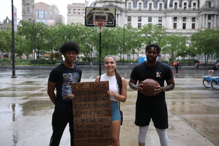 Khalil Gardener (left), Stephania Ergemlidze, and Jaquill Shackelford are trying to ease Center City tension by wheeling her basketball standard to various locations and inviting people to play. It has been used by police and protesters alike.