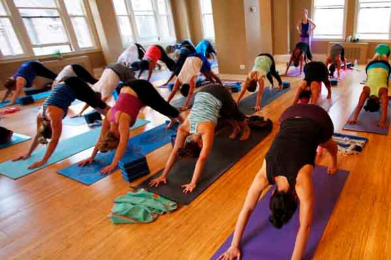 The class in down dog at Maha Yoga in downtown Philadelphia on Thursday, June 20, 2013. MICHAEL S. WIRTZ / Staff Photographer.
