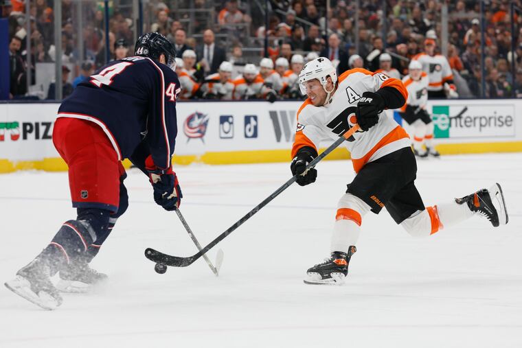 Philadelphia Flyers' Cam Atkinson, right, shoots the puck as Columbus Blue Jackets' Vladislav Gavrikov defends during the first period of an NHL hockey game Thursday, April 7, 2022, in Columbus, Ohio. (AP Photo/Jay LaPrete)